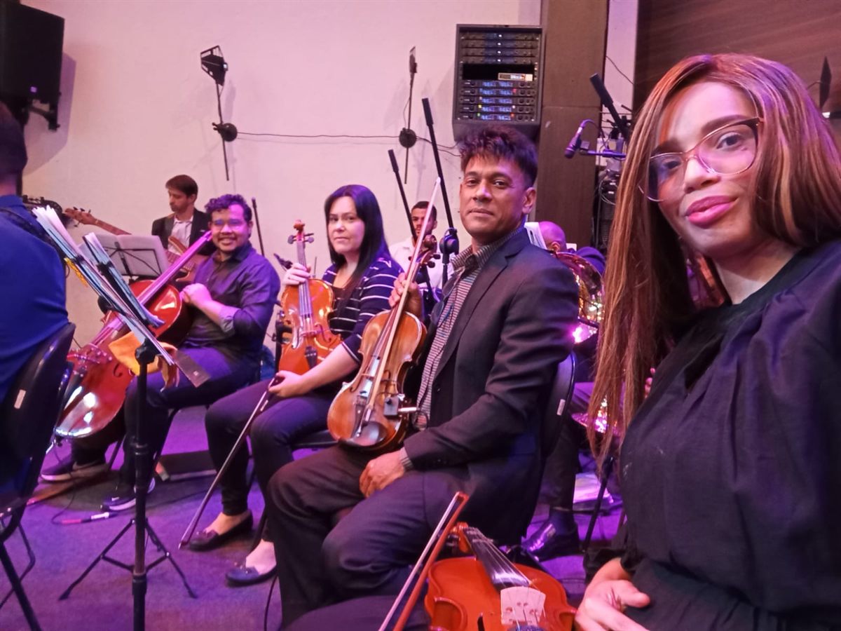 Integrantes do naipe de cordas sorrindo antes de uma apresentação